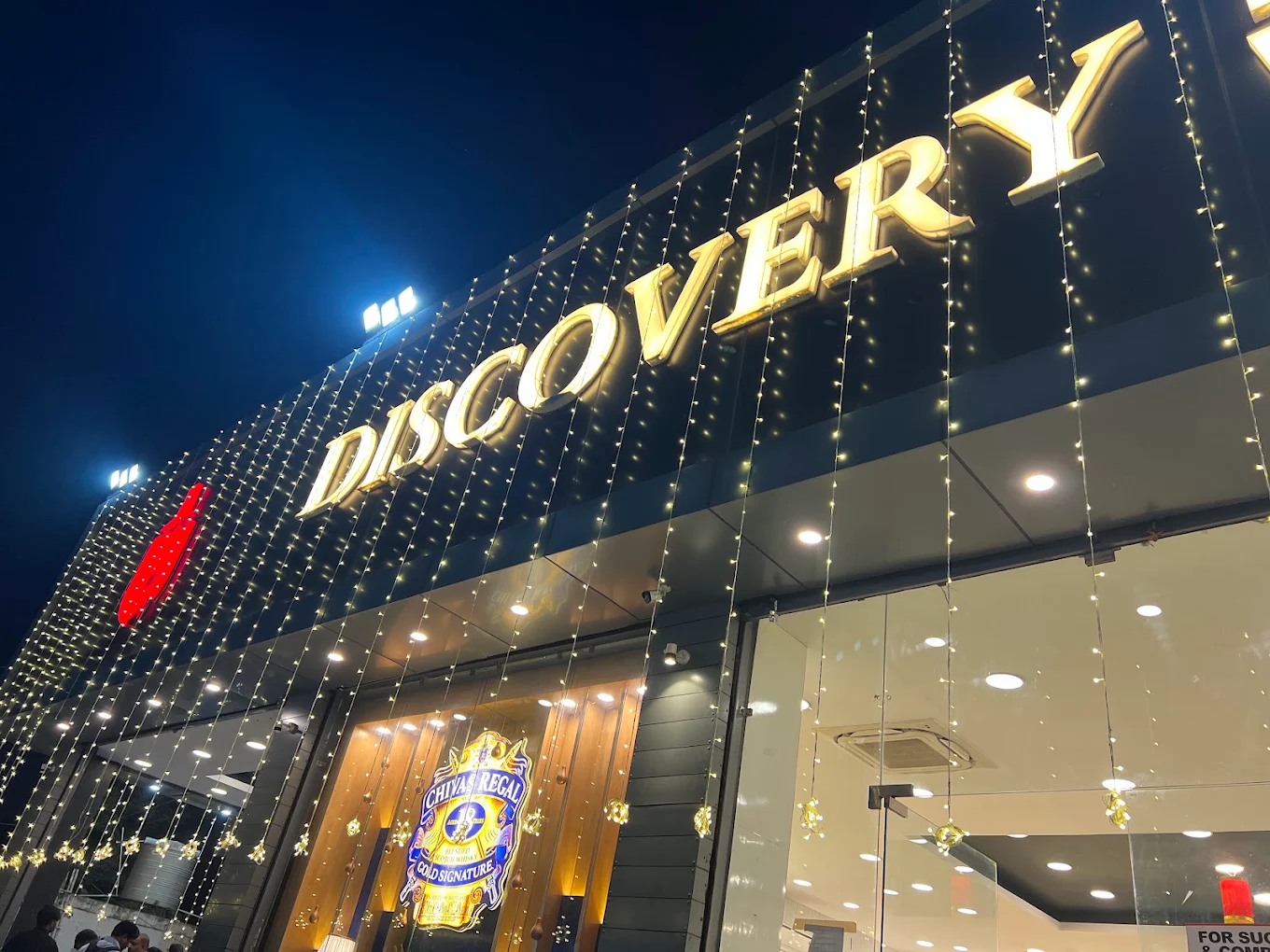 Discovery Wines storefront illuminated at night